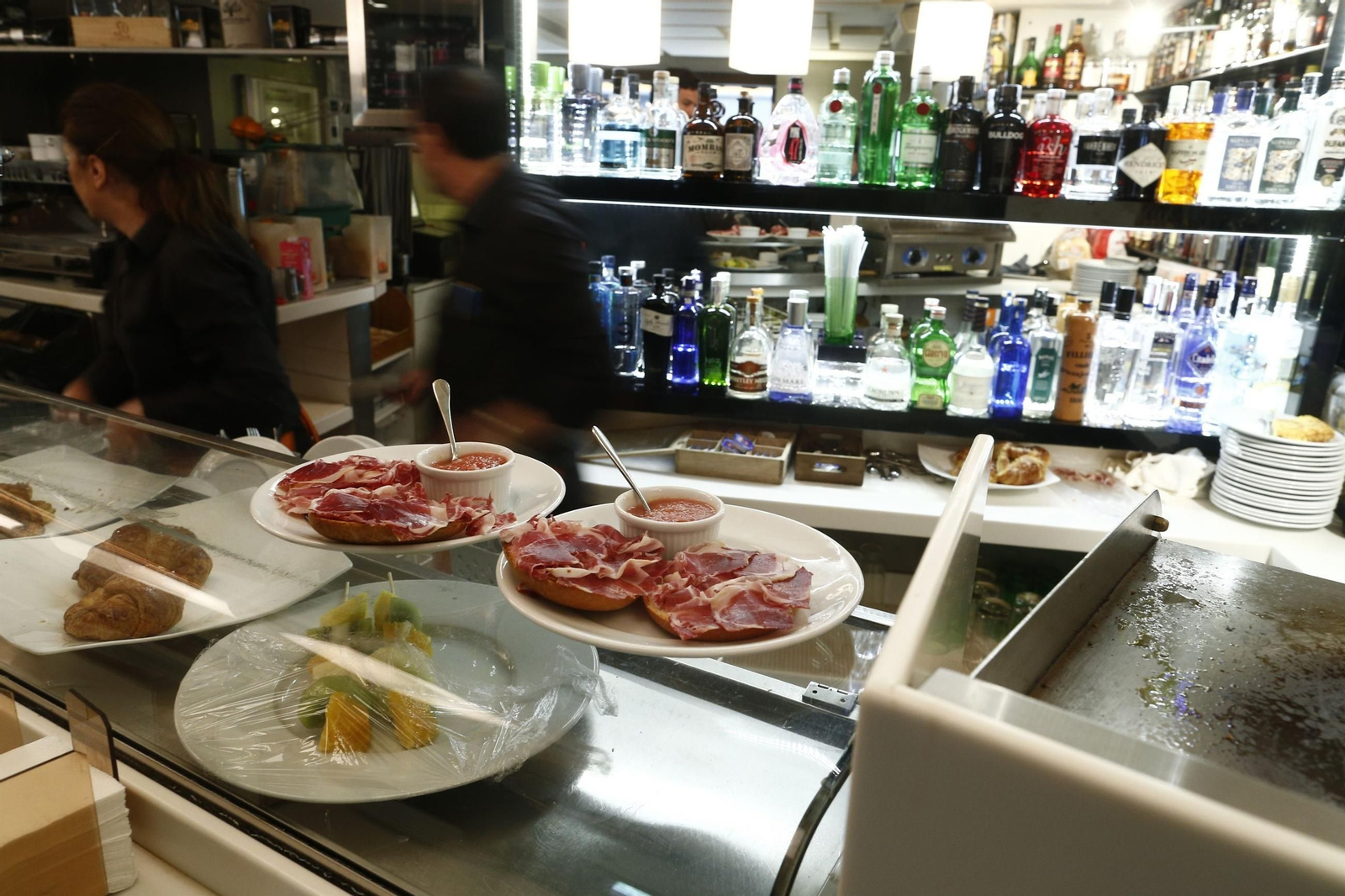 Dos camareros, trabajando en un establecimiento de hostelería.
