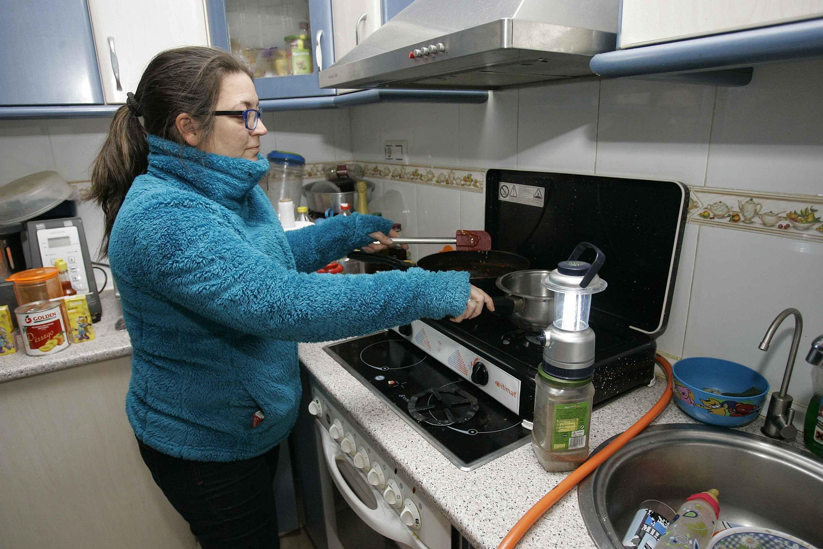 Imagen de archivo de una mujer cocinando junto a un candil en su vivienda.