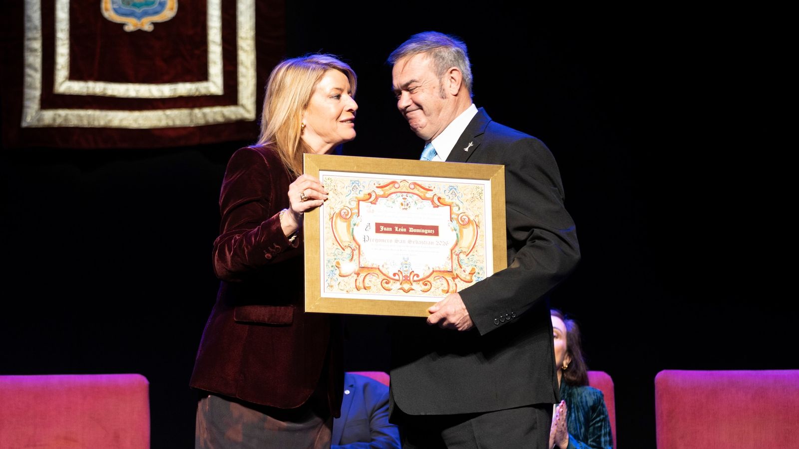 Pilar Miranda dándole el reconocimiento al pregonero, Juan León.