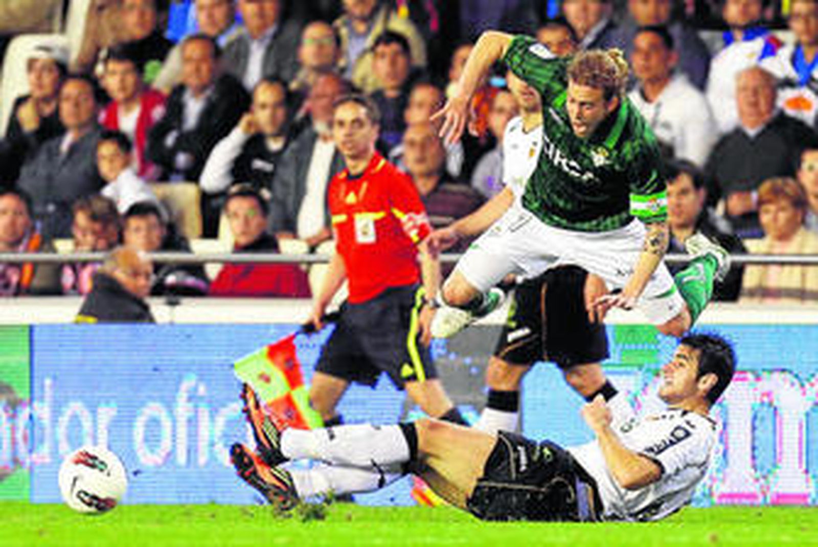 1. Cañas recibe la entrada fuerte de Barragán, que le hace saltar en el aire. 2. David Albelda, que sobresale por encima de sus compañeros, se abraza con ellos tras uno de los cuatro goles que el Valencia le endosó anoche al Betis. 3. Desde la banda Unai Emery lanza gritos a sus jugadores mientras el partido está en juego. Canales, uno de los valencianistas más destacados, espera para recibir el balón.