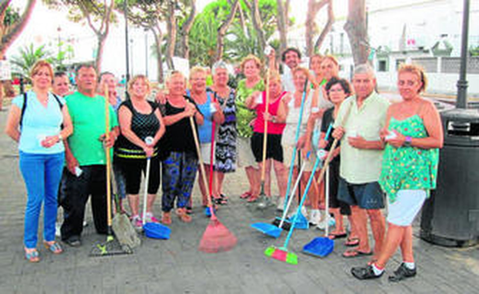 Los vecinos de la barriada de La Playa que participaron en la jornada cívica posan con sus escobas y recogedores.