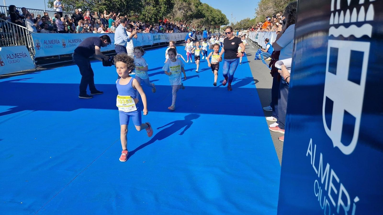 Los jóvenes atletas completan su carrera infantil ante la ovación de los espectadores.