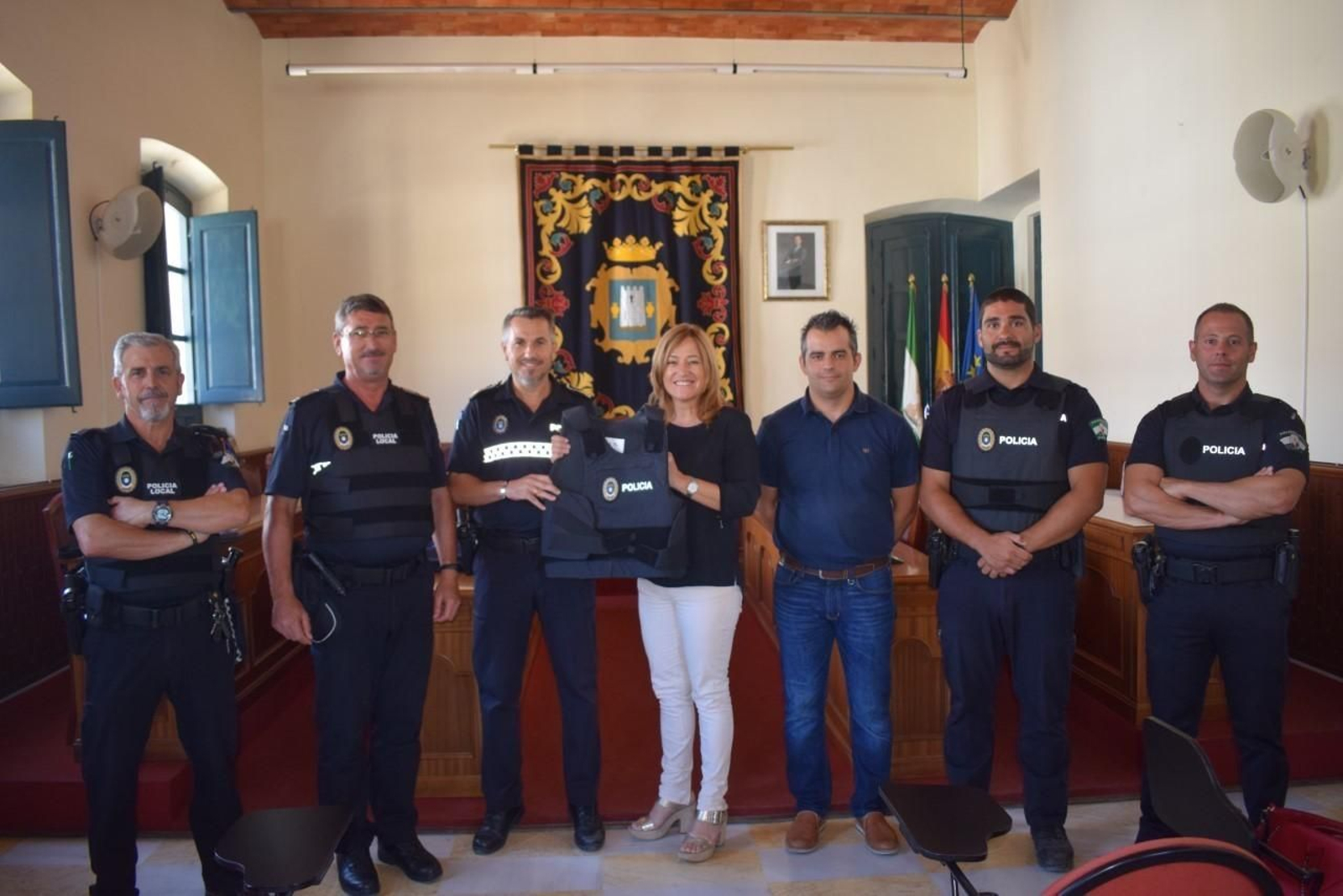 La alcaldesa junto a miembros de la policía muestran el chaleco antibalas.