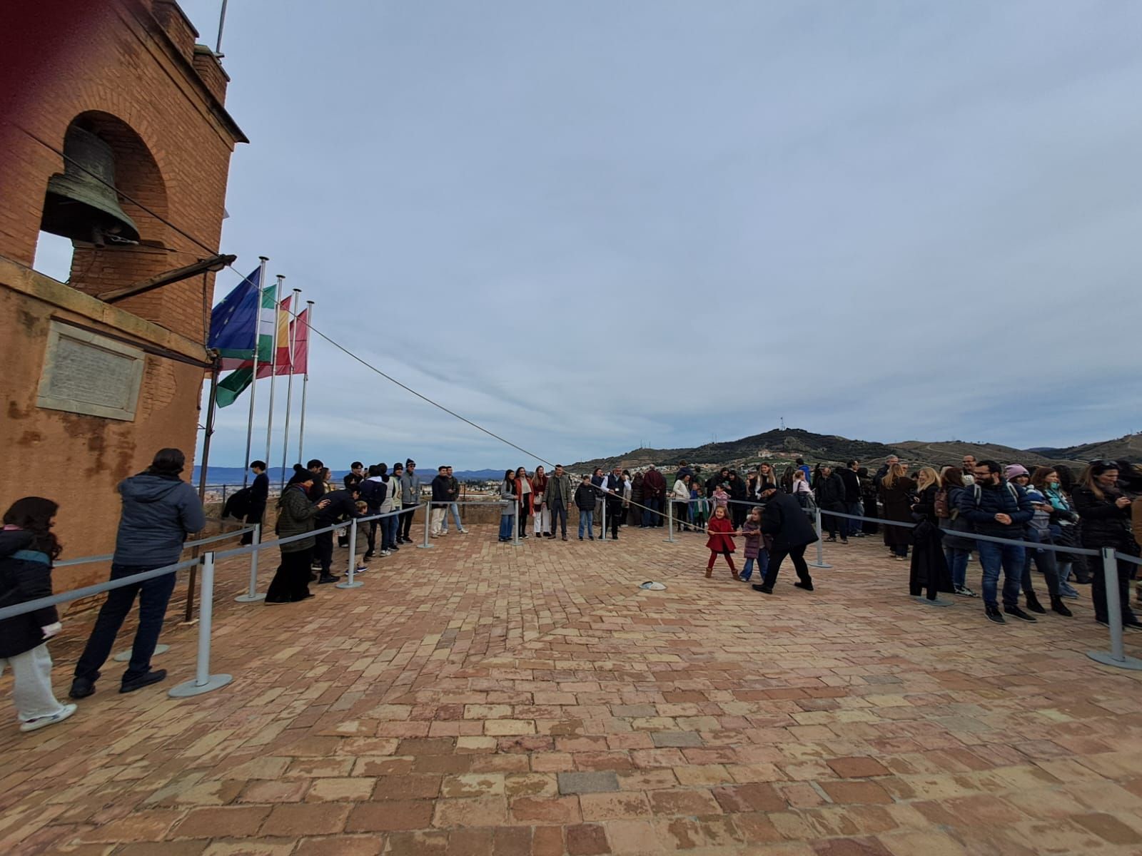 Una familia tocando la campana de la Torre de la Vela este 2 de enero