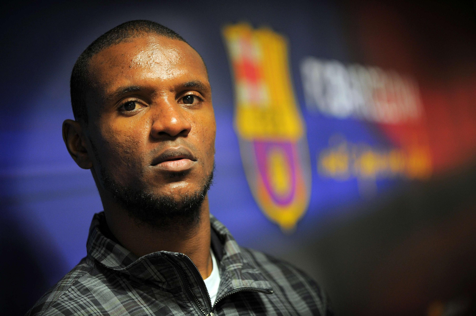 Abidal posa ante el escudo del Barcelona.