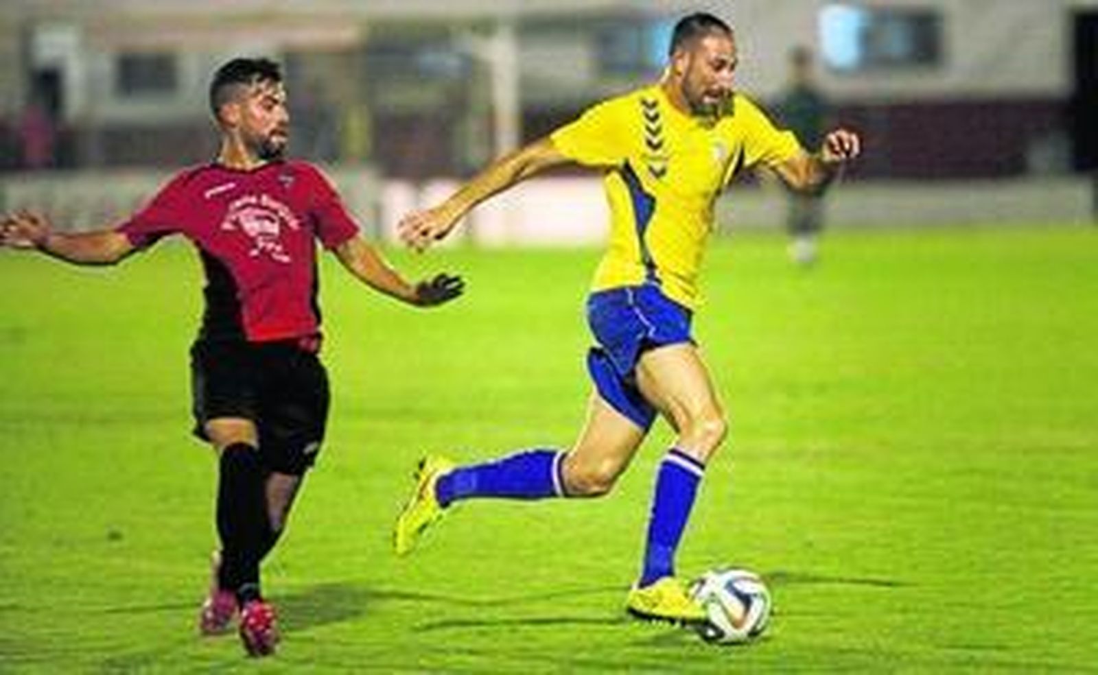 Juanjo avanza con el balón dejando atrás a un futbolista de la Roteña.