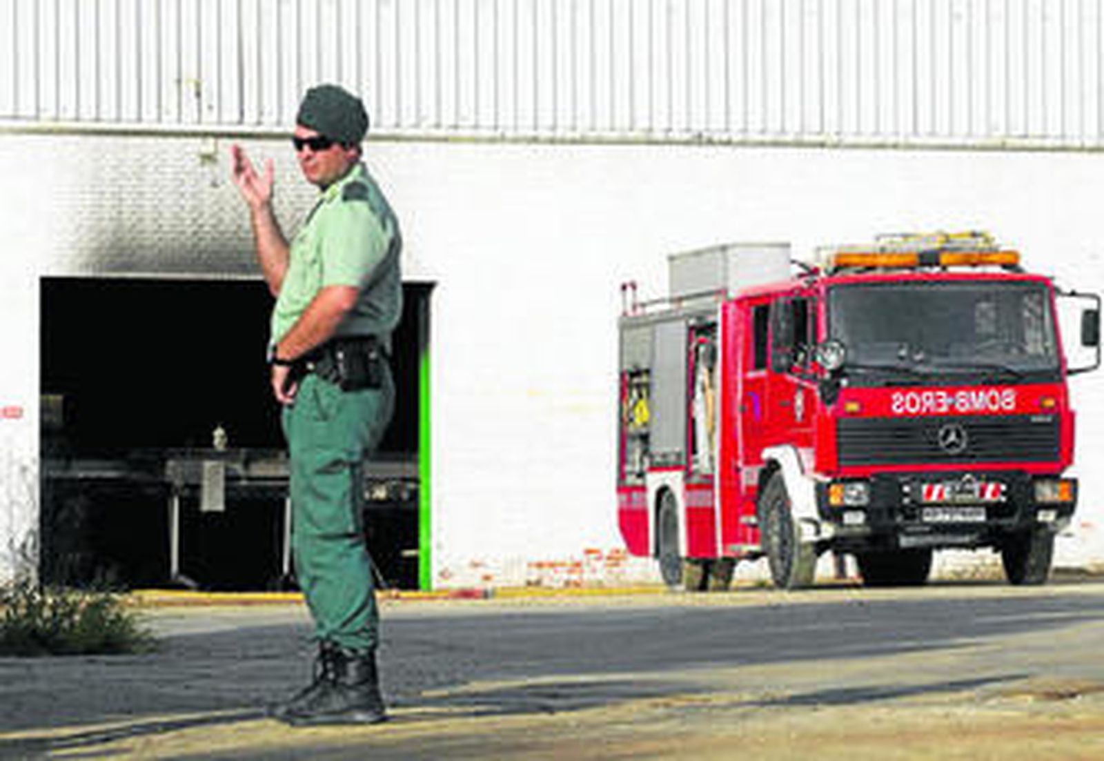 Un guardia civil vigilaba ayer por la mañana la planta embotelladora de Casarabonela tras el incendio.
