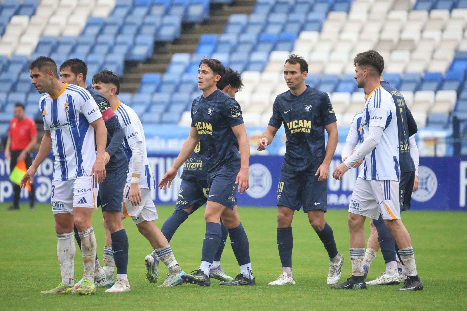 Jugadores de Recre y UCAM en un balón parado.
