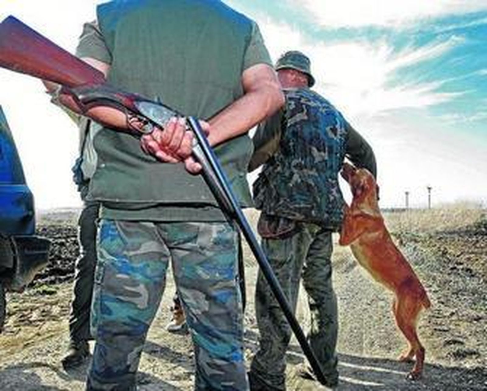 Varios cazadores, con un perro en una montería.