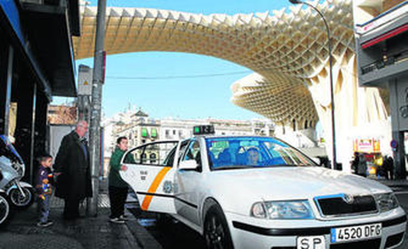 Una familia sube a un taxi en la parada de la Plaza de la Encarnación.