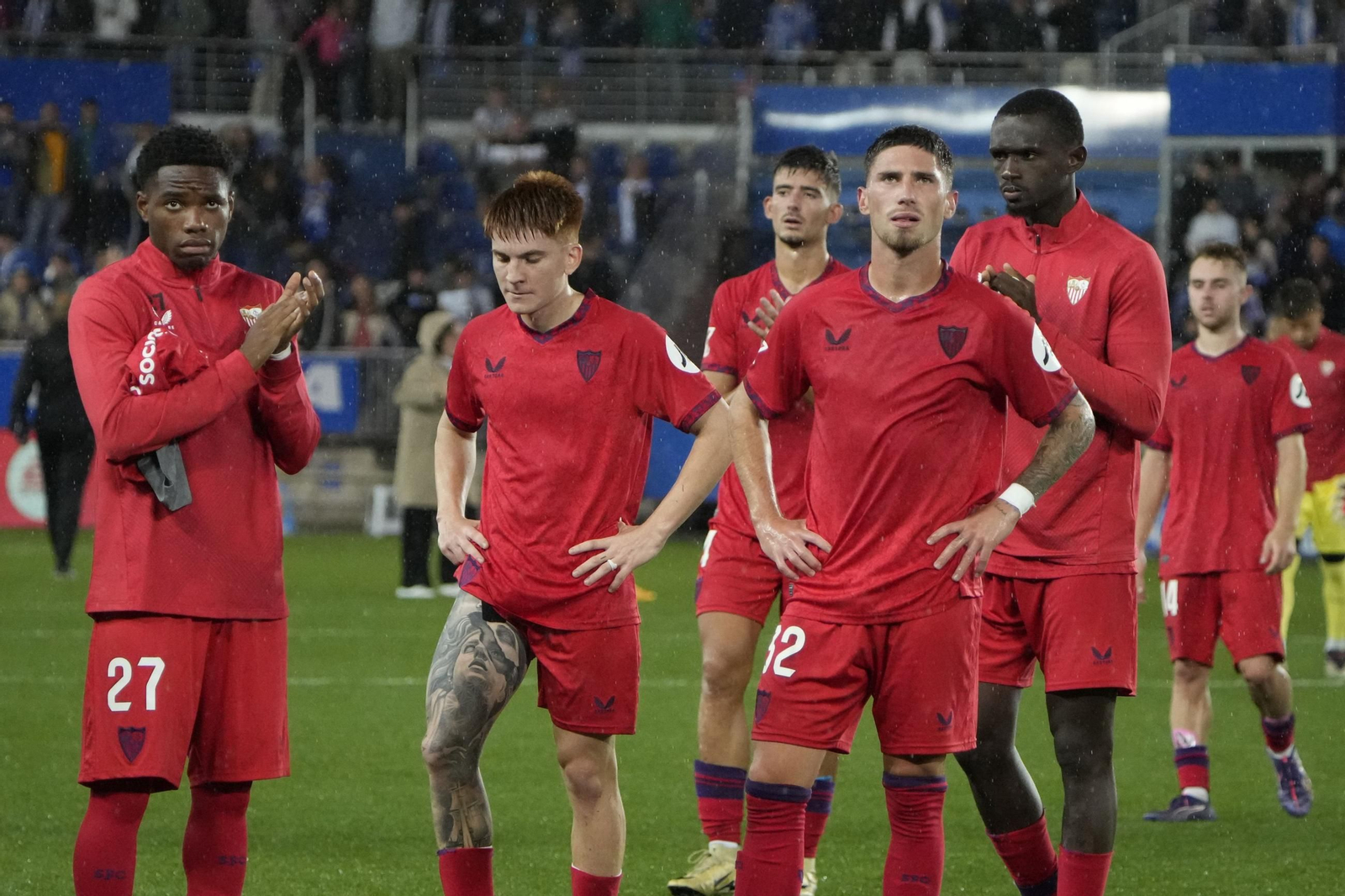 Algunos futbolistas del Sevilla, cariacontecidos delante de sus aficionados.
