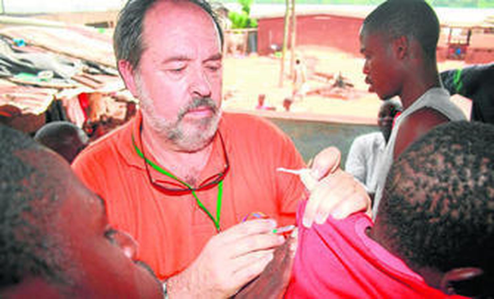 El doctor Alfonso Carmona Martínez vacuna a un joven.
