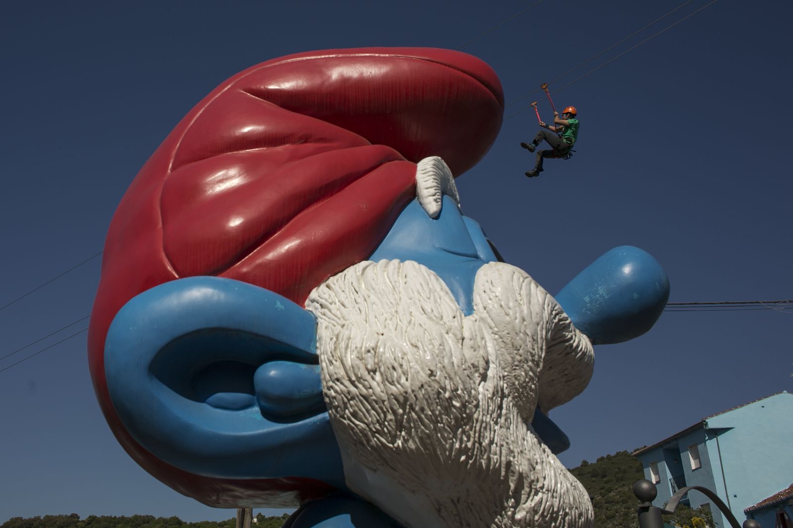 Un usuario de la nueva tirolina pasa sobre la imagen de Papá Pitufo.