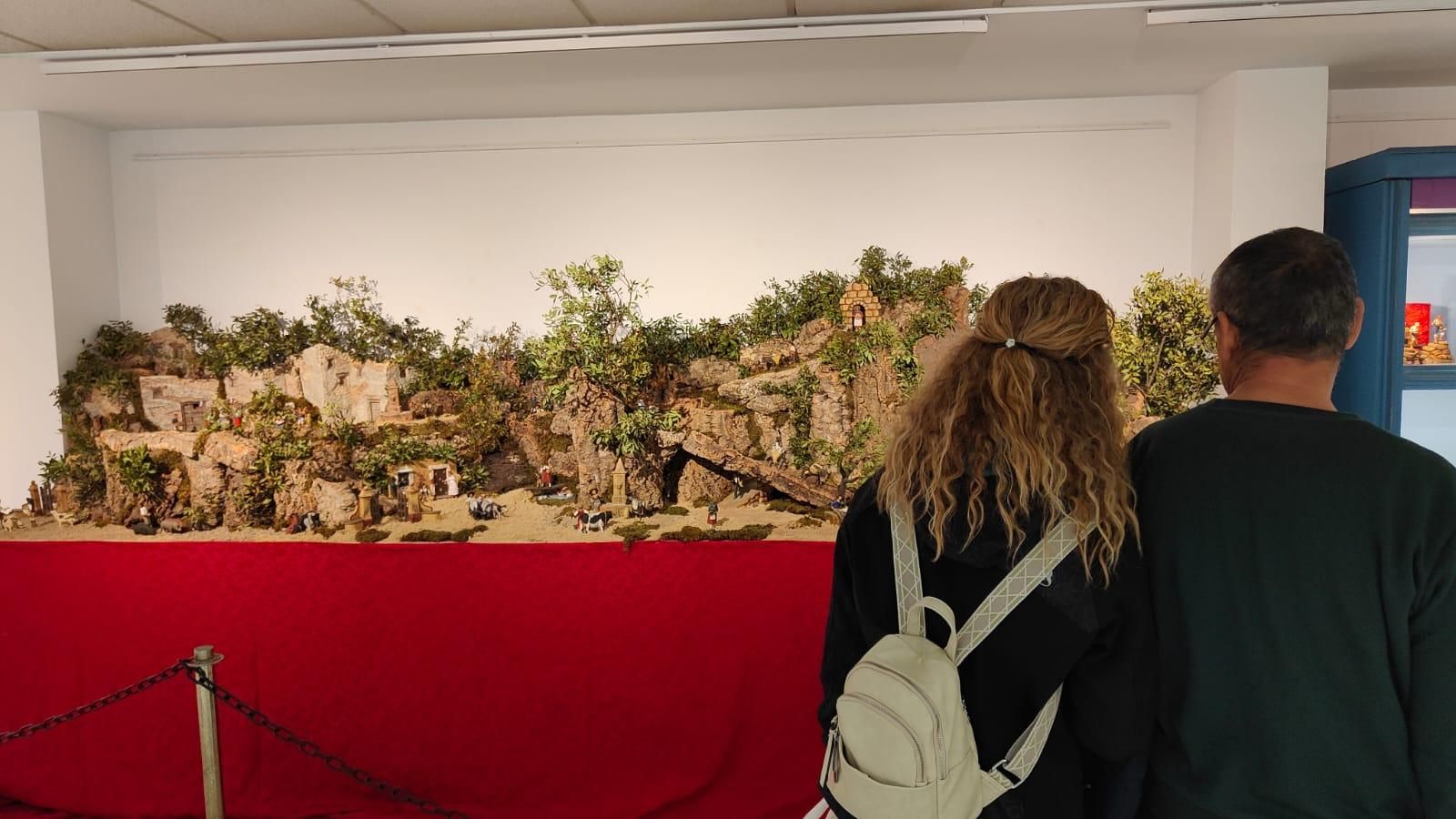 Una pareja contempla el nacimiento instalado en la muestra.