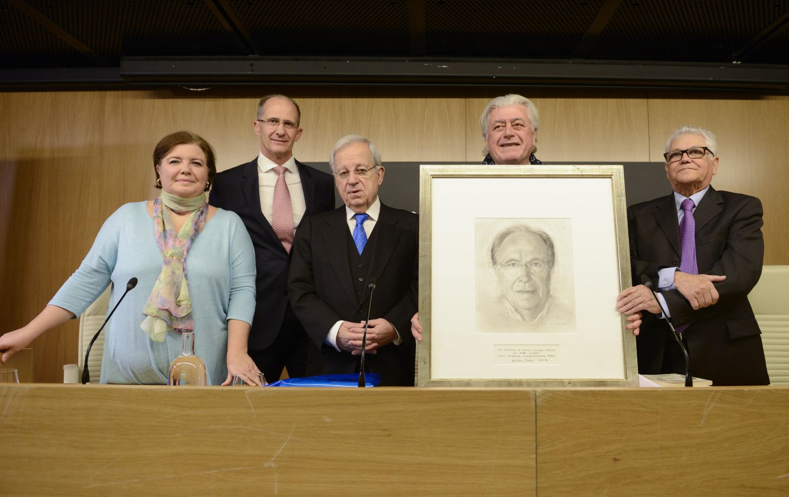 De izquierda a derecha, Rosa García Perea, de Almuzara, Arturo Moya Jr., Jaime Ignacio del Burgo,  Fernando Yélamos y Juan de Dios Mellado, junto a un retrato de Moya hecho por Reyes de la Lastra.
