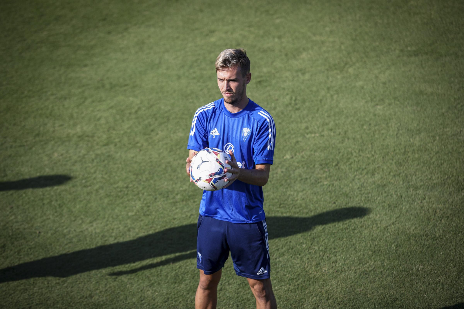 Sergio González, con rostro serio, sostiene un balón en un entreno.