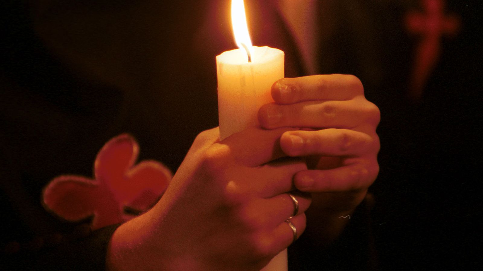 Un nazareno sostiene un cirio.