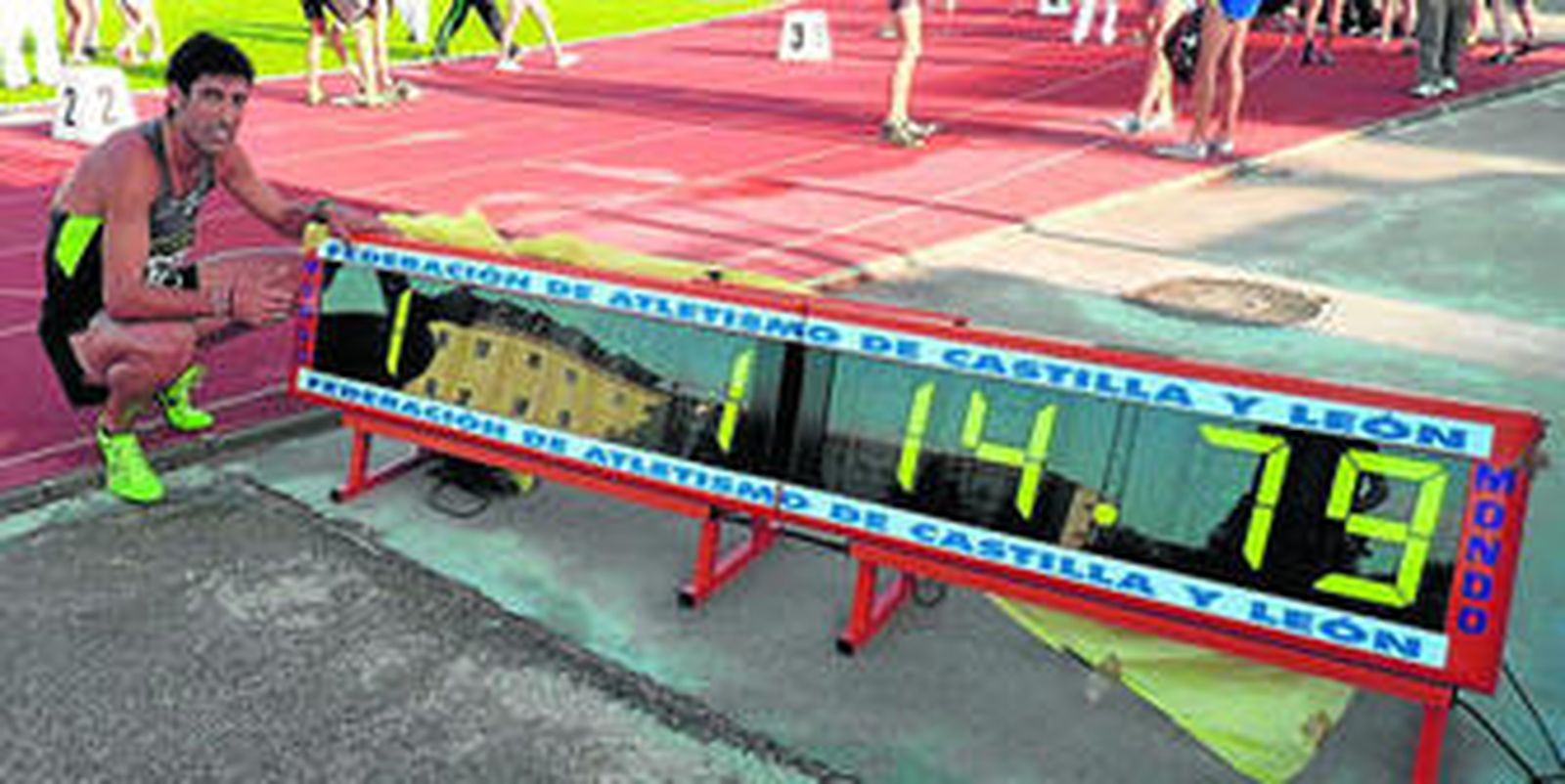 Antonio Reina posa tras la carrera al lado del cronómetro que marca el nuevo récord español en 600: 1.14,79.