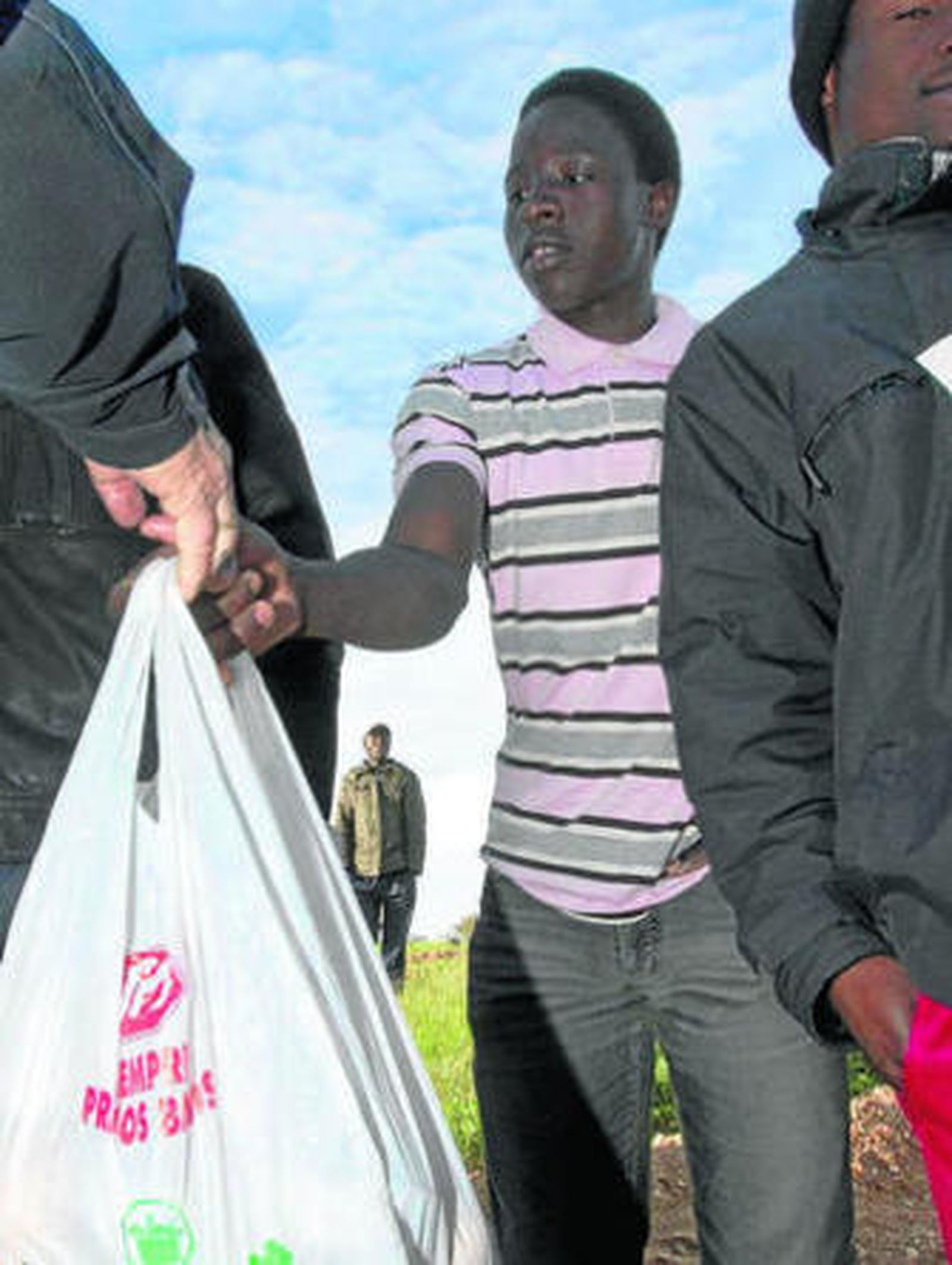 Uno de los inmigrantes recibe la comida de manos de Mora.