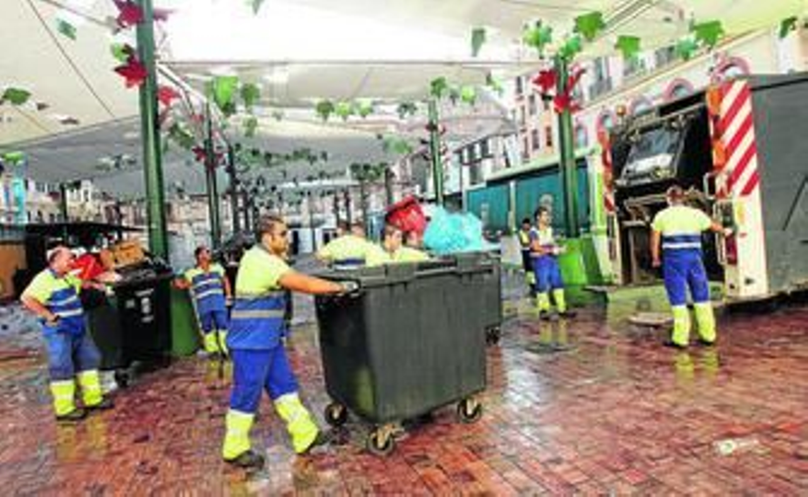 Trabajadores de Limasa recogen la basura en la última Feria de Agosto.