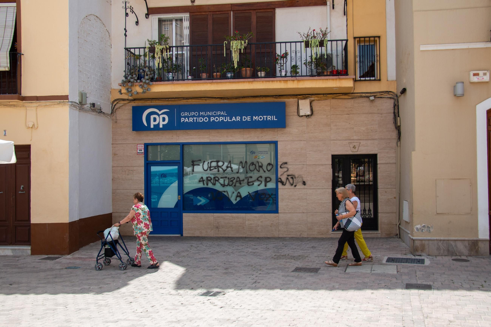 Varias personas pasan por la puerta de la sede del PP de Motril, que ha sido vandalizada Varias personas pasan por la puerta de la sede del PP de Motril, que ha sido vandalizada