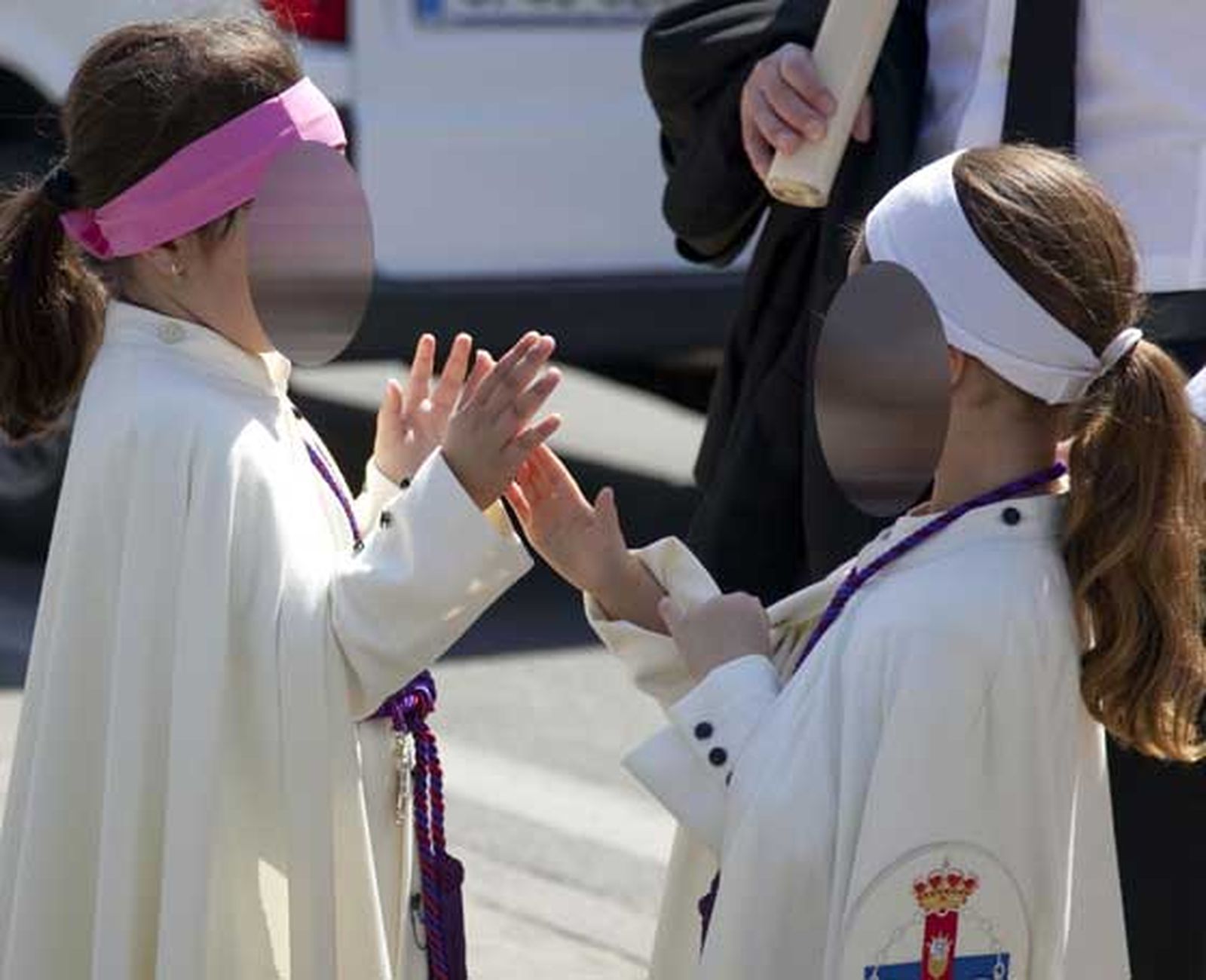 Dos niñas nazarenas amenizan el tiempo de paradas de la larga estación de penitencia de la Hermandad del Polígono de San Pablo.

Foto: Jaime Martínez