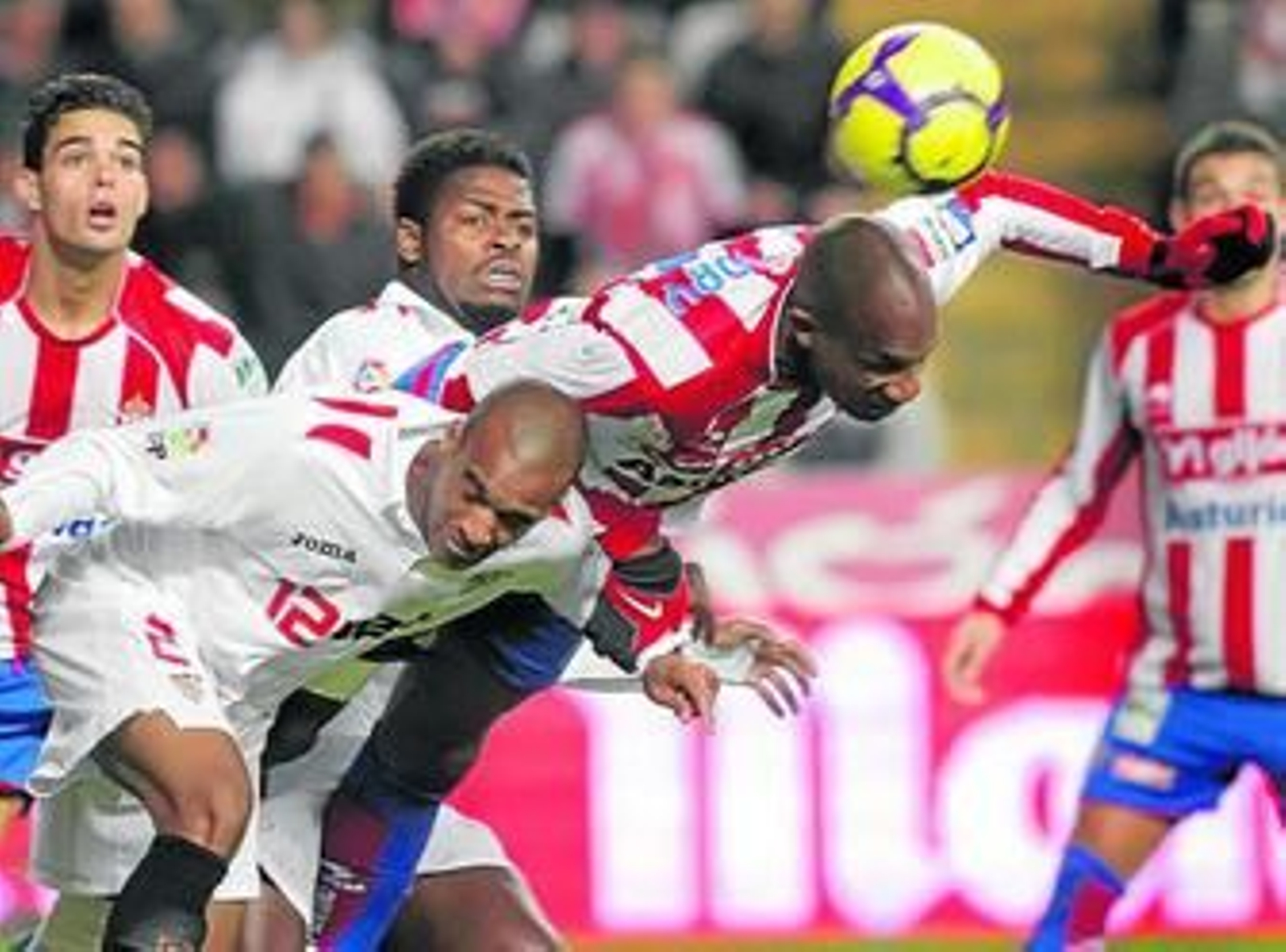 El sevillista Konko y el central sportinguista Gregory se lanzan en busca de un balón aéreo.