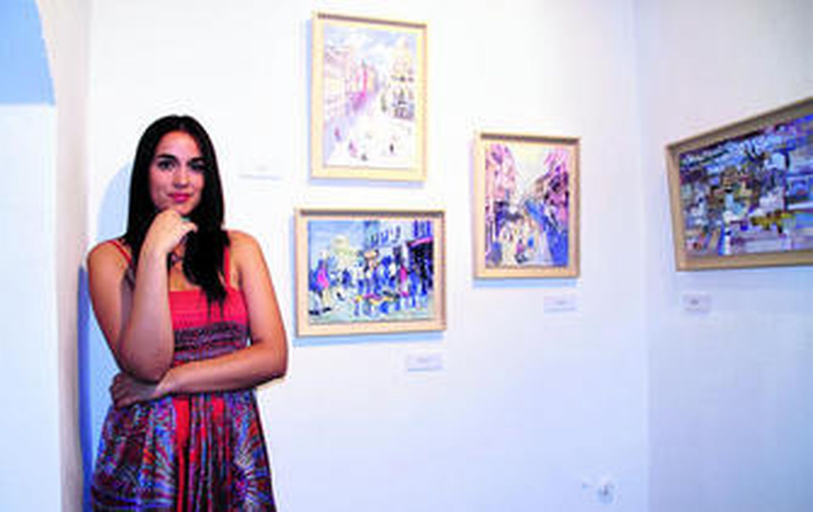 Virginia Saldaña, junto a los cuadros de temática sevillana que expone en la galería Rosa Cabalga de Ayamonte.