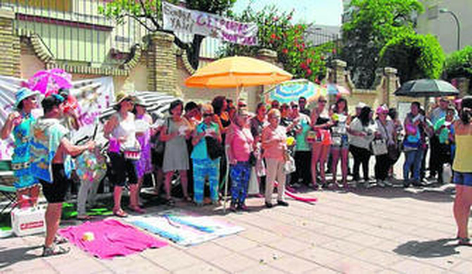 Protesta de los padres del CEIP Arias Montano, con sombrillas y toallas, por la falta de sombra en el patio del colegio.