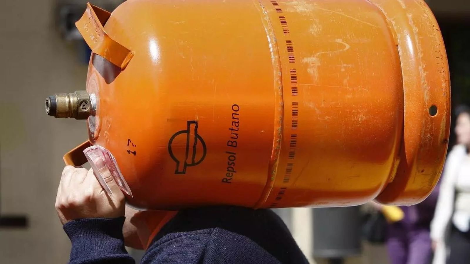 Un repartidor de butano con una bombona a hombros.