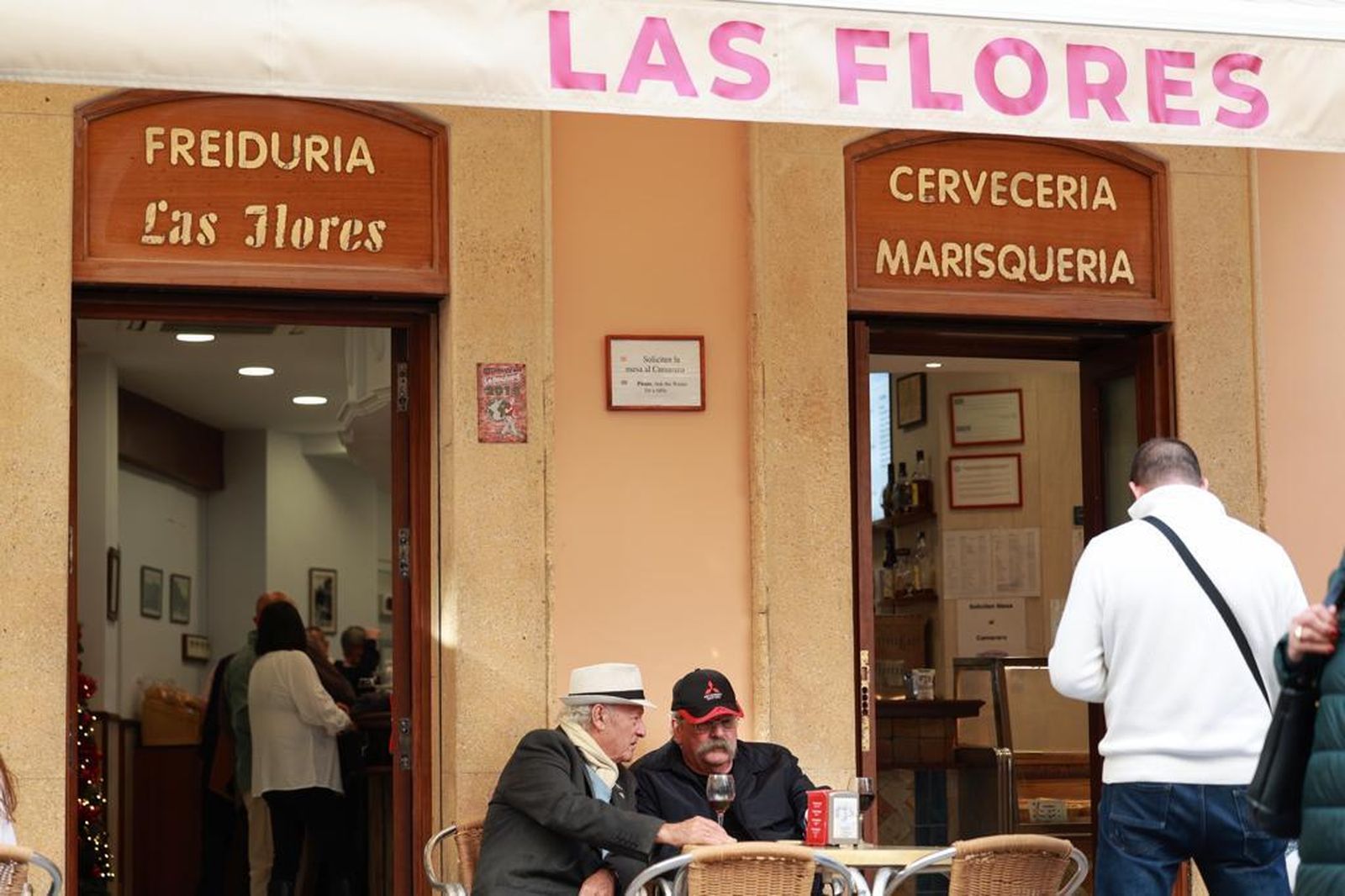 Clientes sentados en la terraza de la Freiduría Las Flores el día de su reapertura.