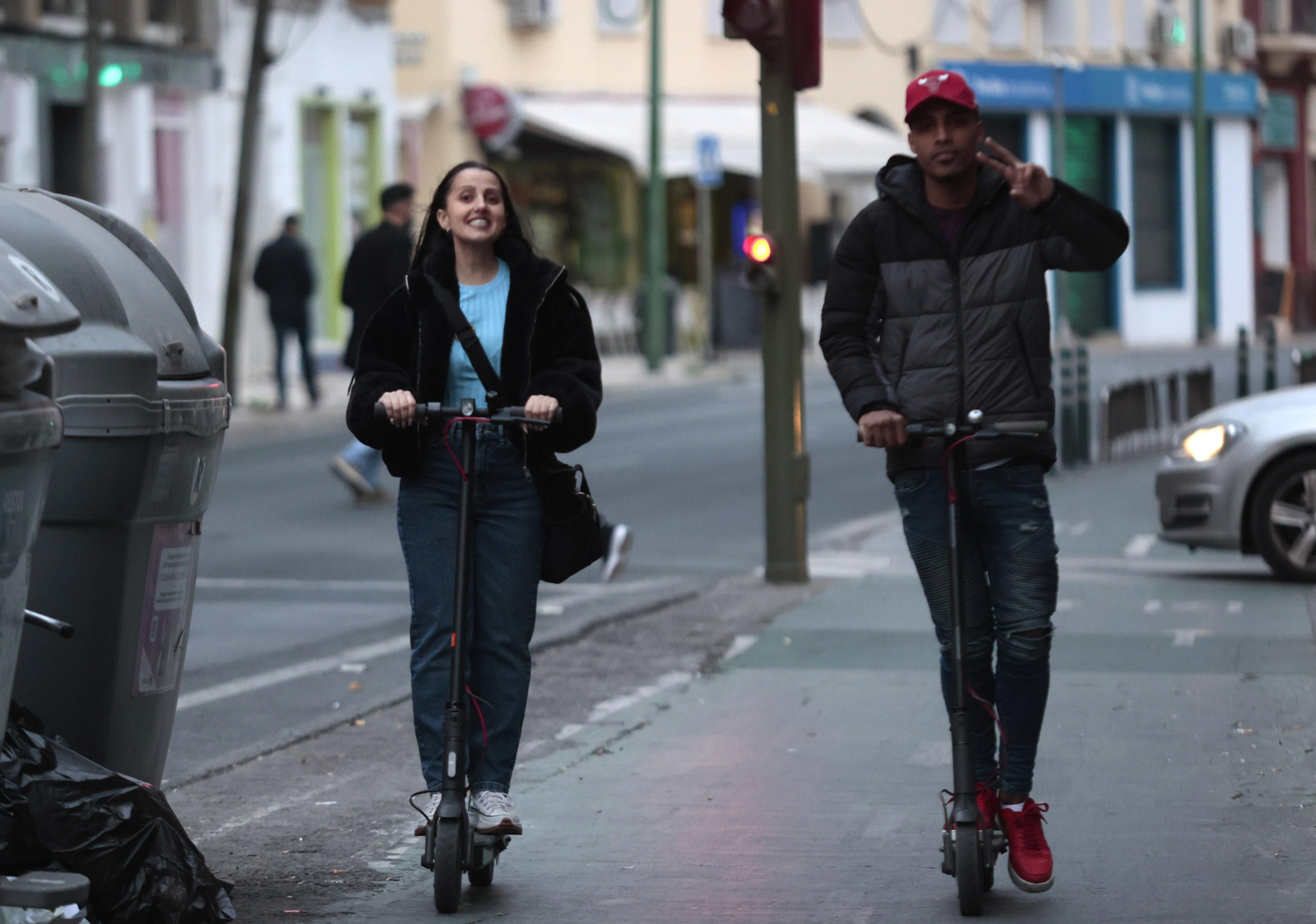 Dos usuarios de patinetes por el carril bici de Sevilla.