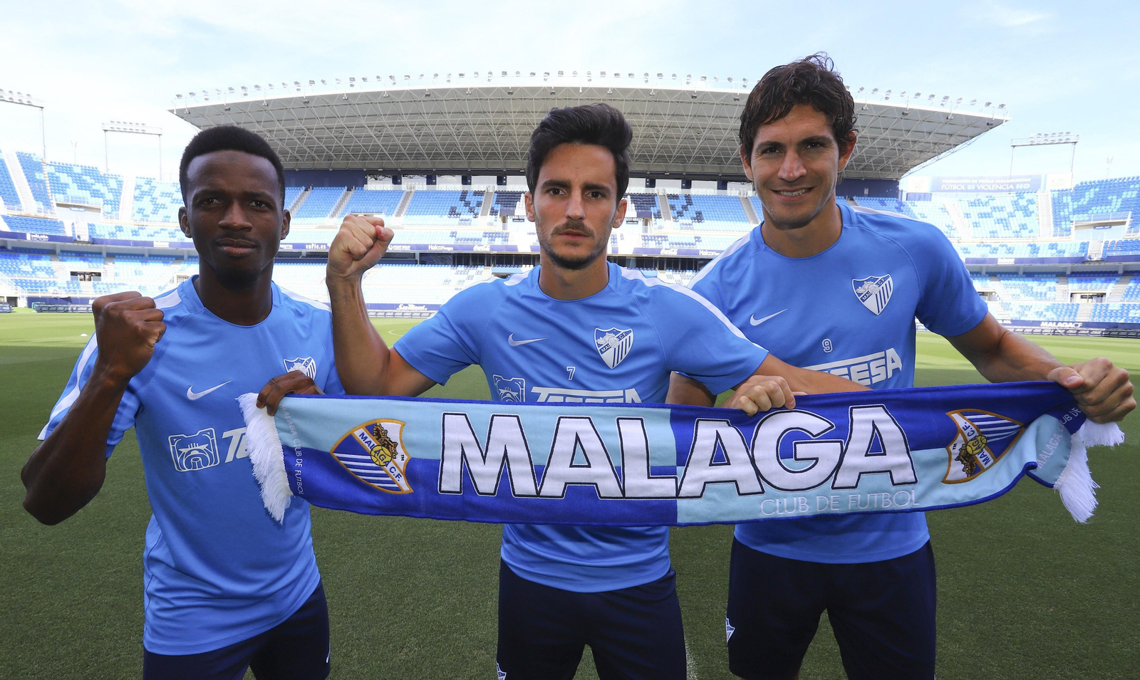 Gustavo Blanco, Juankar y Koné, en las galerías interiores de La Rosaleda, ante el escudo del Málaga.