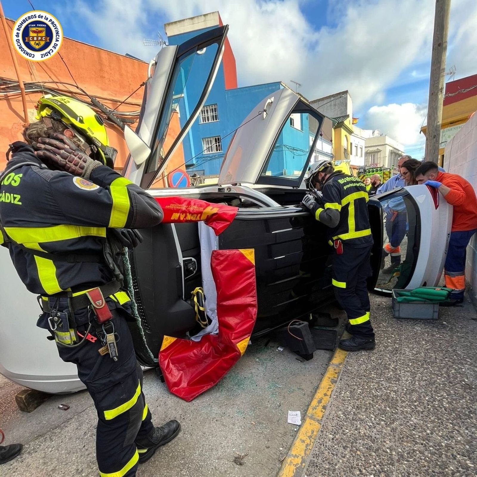 Un grupo de bomberos, junto al coche siniestrado