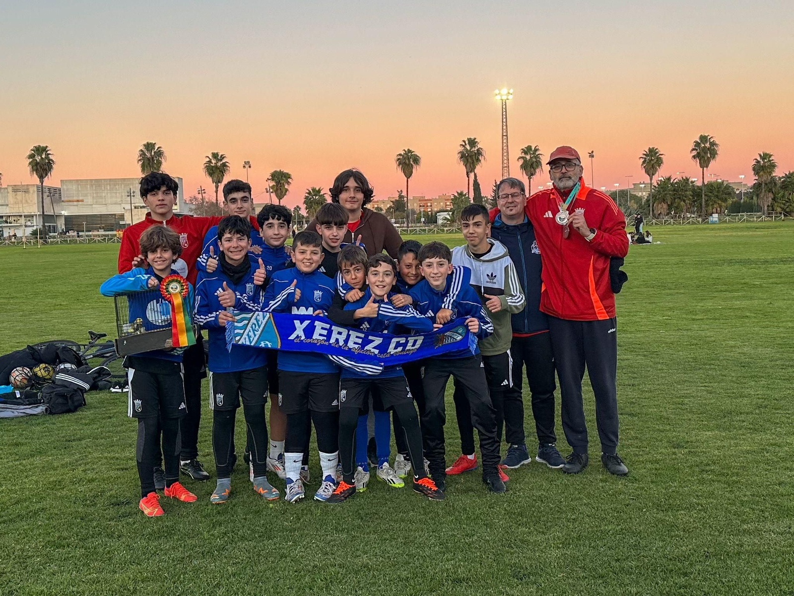 Antonio Labrador, con sus medallas y sus canarios junto a los infantiles del Xerez CD C a los que entrena.