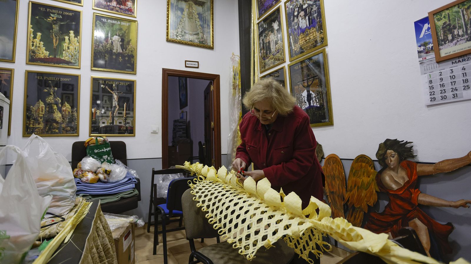 Rosa González coloca los adornos a un palma.