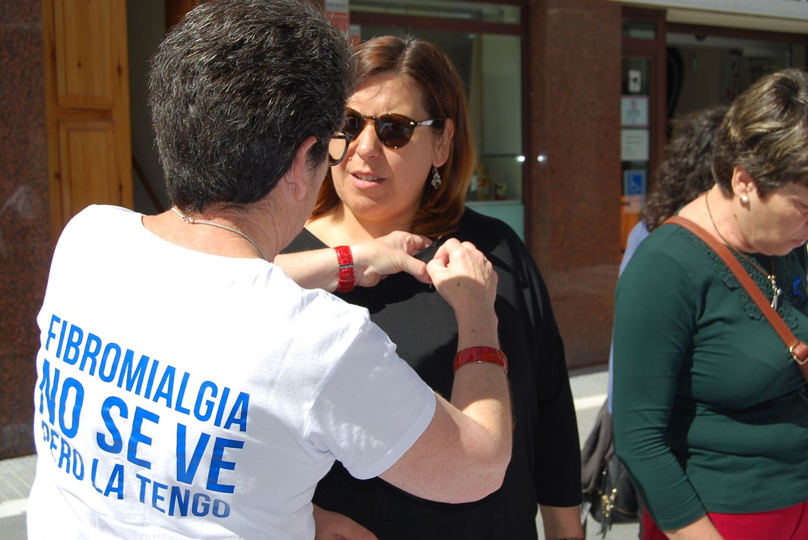 Una socia de Afipre coloca un lazo a una mujer.