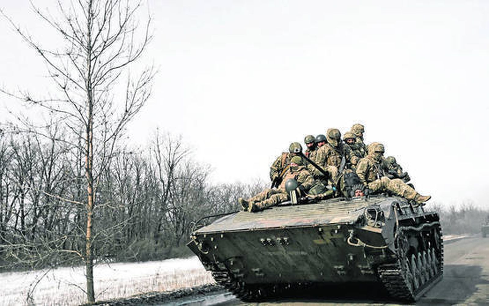 Militares ucranianos se transportan encima de un APC en una carretera en Bajmut.