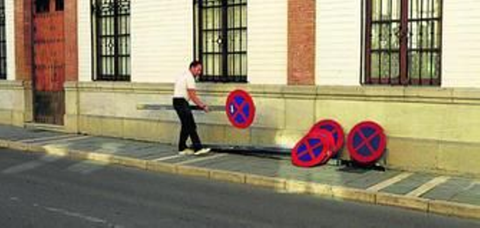 Un operario municipal retira las señales de indicación de aparcamiento.