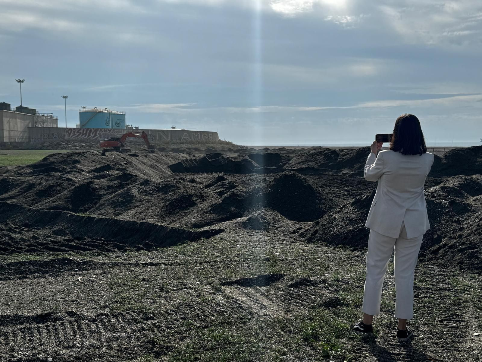 Una mujer fotografía el inicio de los trabajos en Playa del Cable Una mujer fotografía el inicio de los trabajos en Playa del Cable