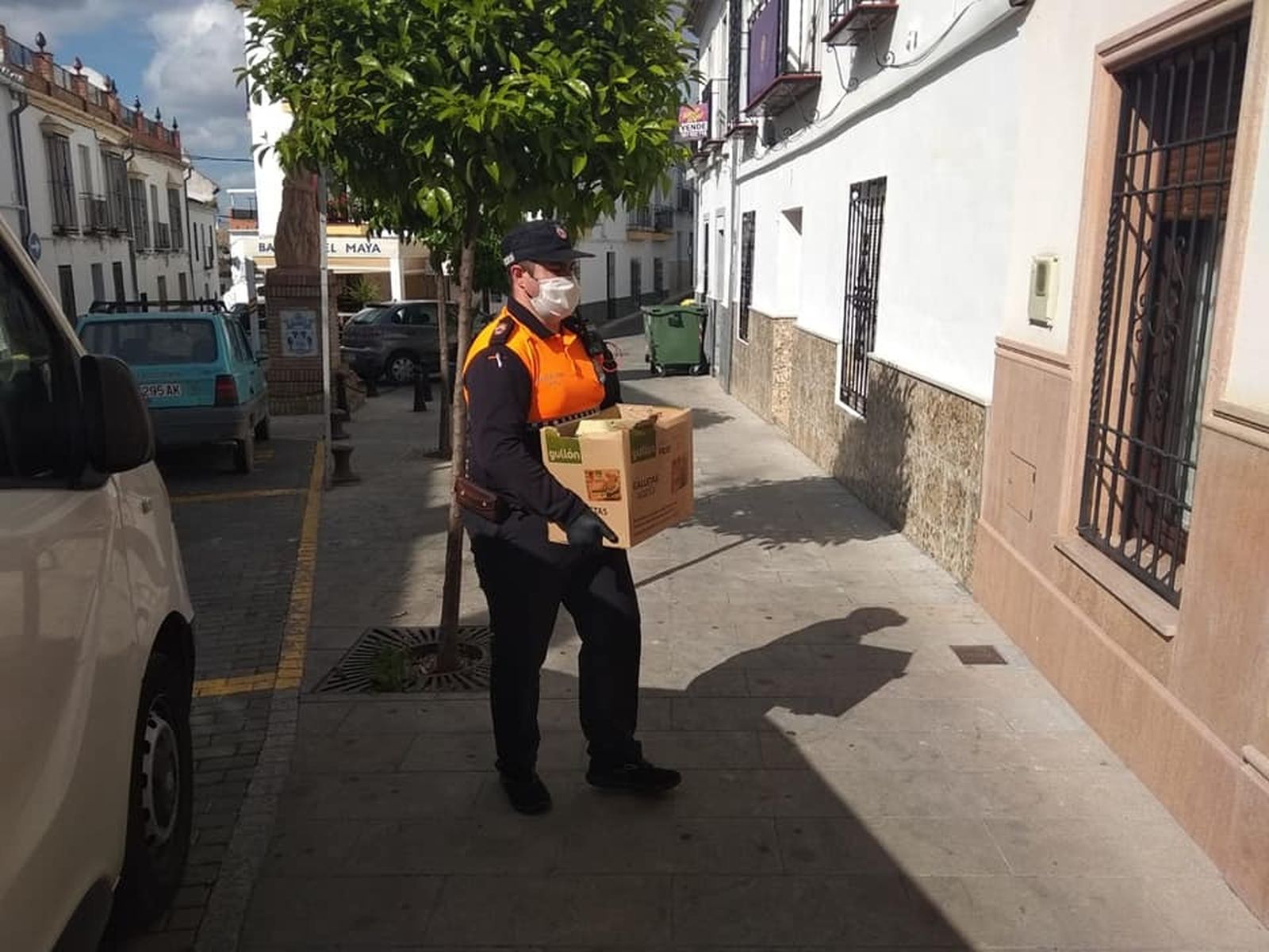 Un voluntario de Protección Civil reparte alimentos en La Rambla.