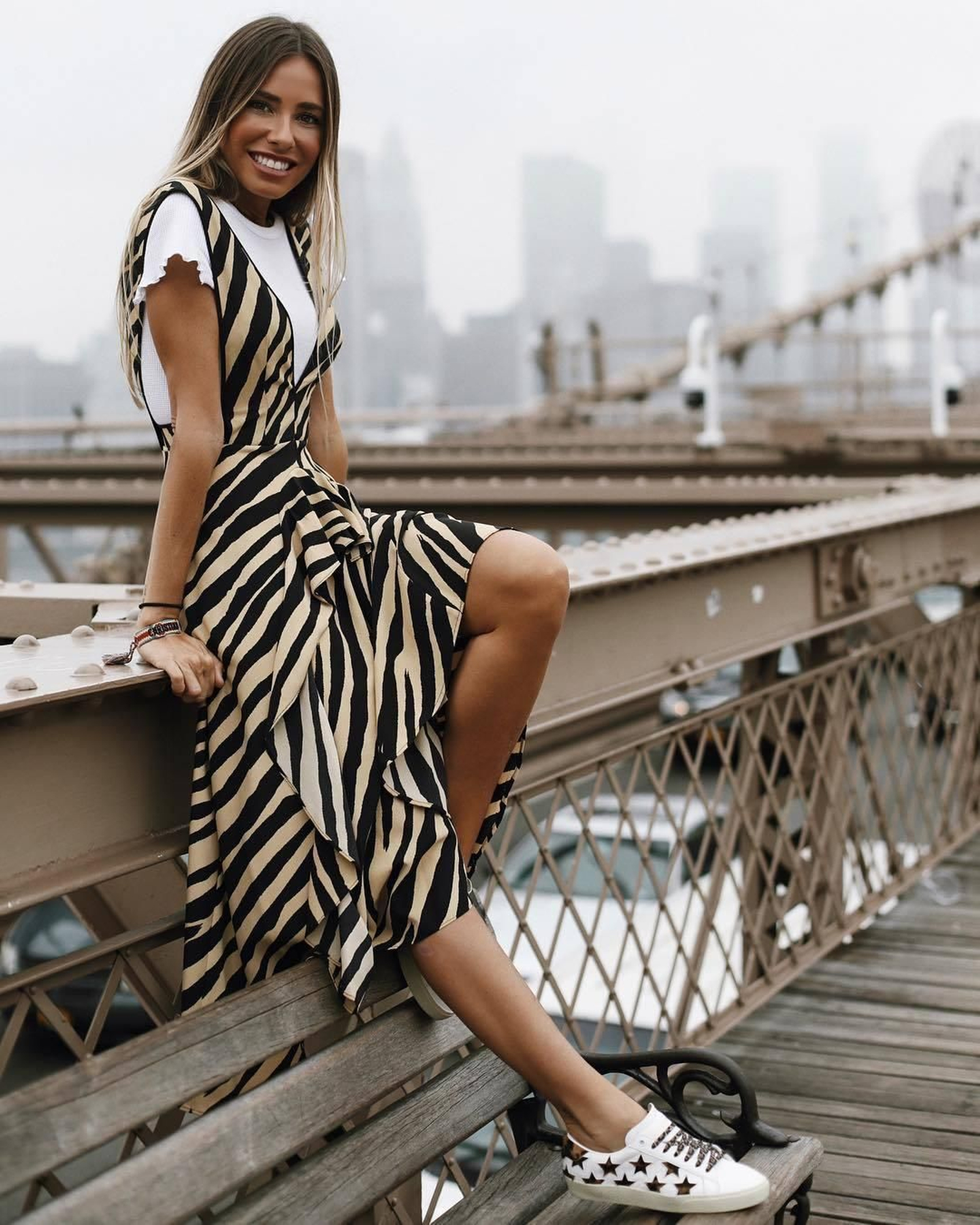 Marta Carriedo se atreve con un animal print menos visto, el de zebra, con este espectacular vestido de su propia colección. Ha convertido lo que podría ser una prenda de noche en un look de calle ideal superponiéndolo a este top de Topshop y combinándolo con zapatillas deportivas de Yves Saint Laurent.
