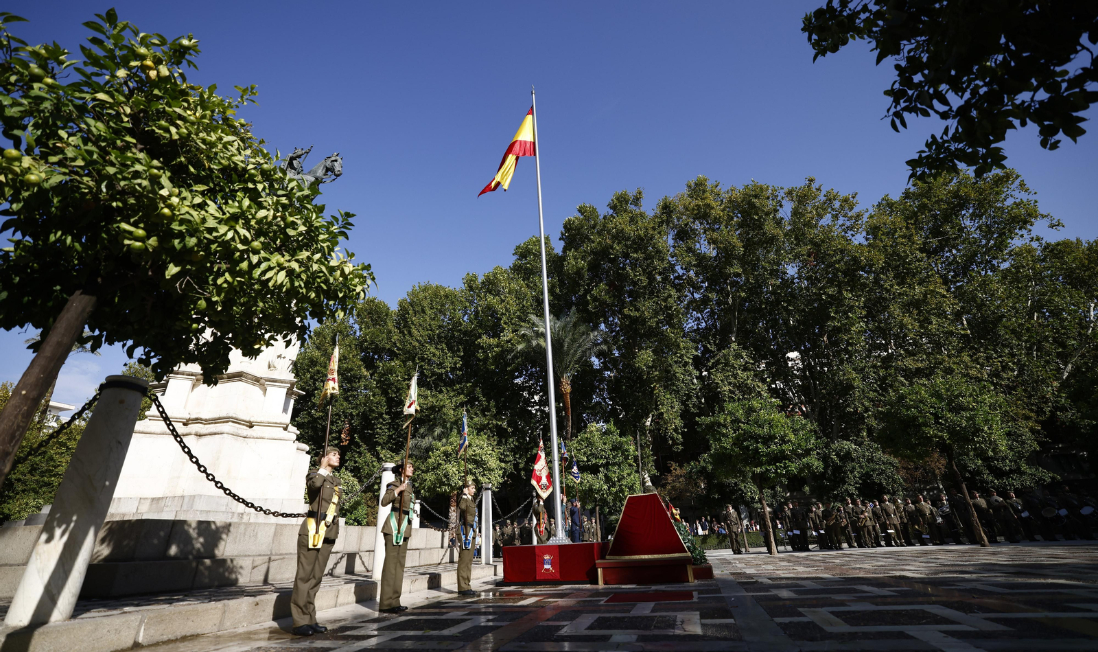 El izado de bandera y desfile militar por el centro de Sevilla, en imágenes