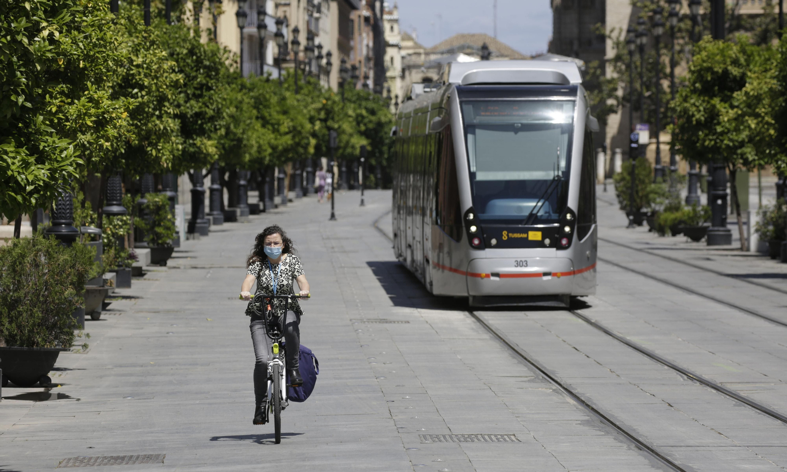 Una joven, en bicicleta por la avenida de la Constitución.