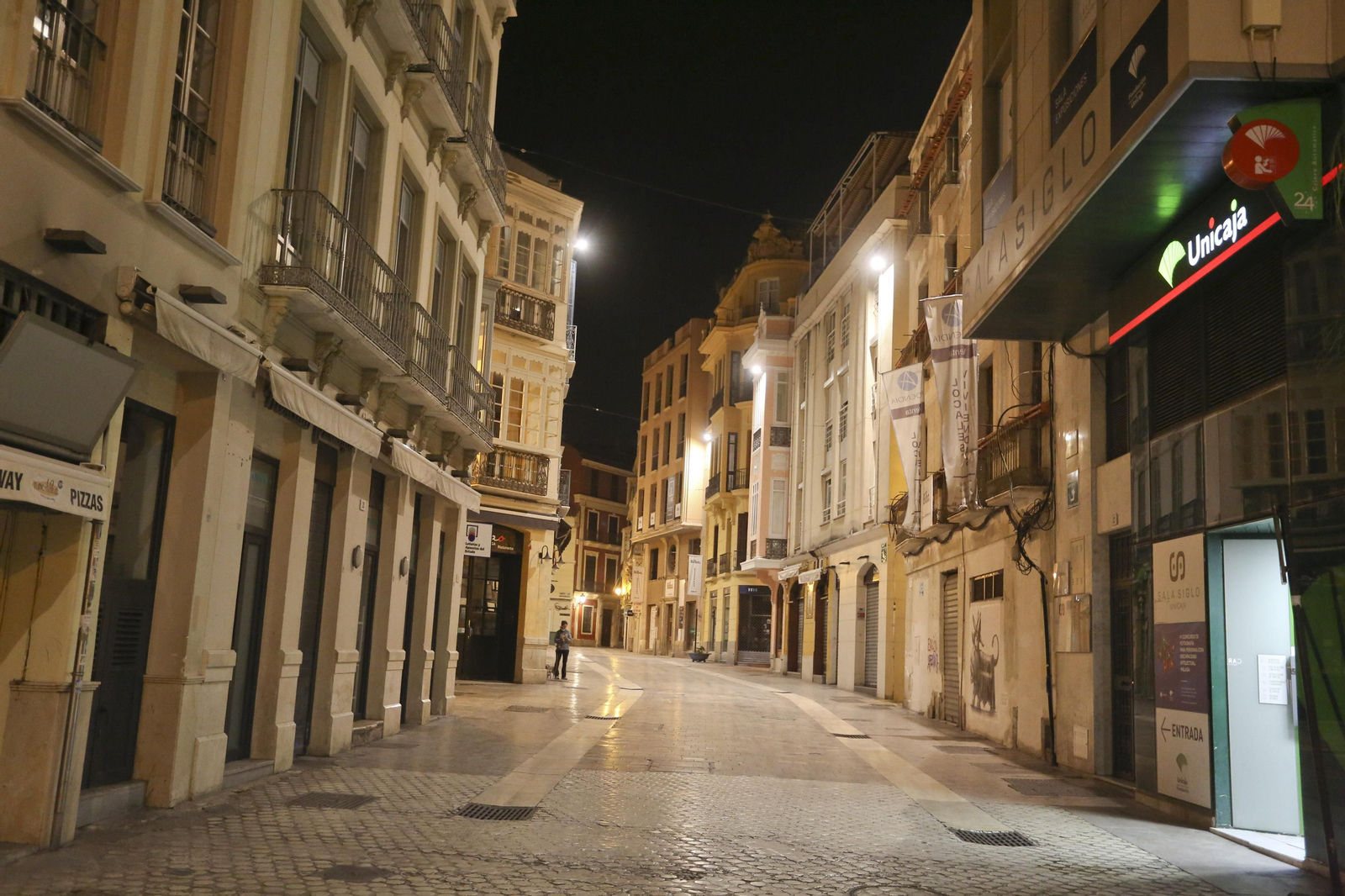 El coronavirus dibuja una noche desierta en el centro de Málaga, en fotos