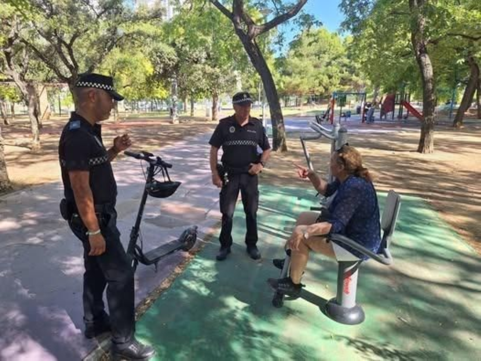 Dos agentes de la Policía Local de Jerez conversan con una vecina en el parque flamecólogo Juan de la Plata