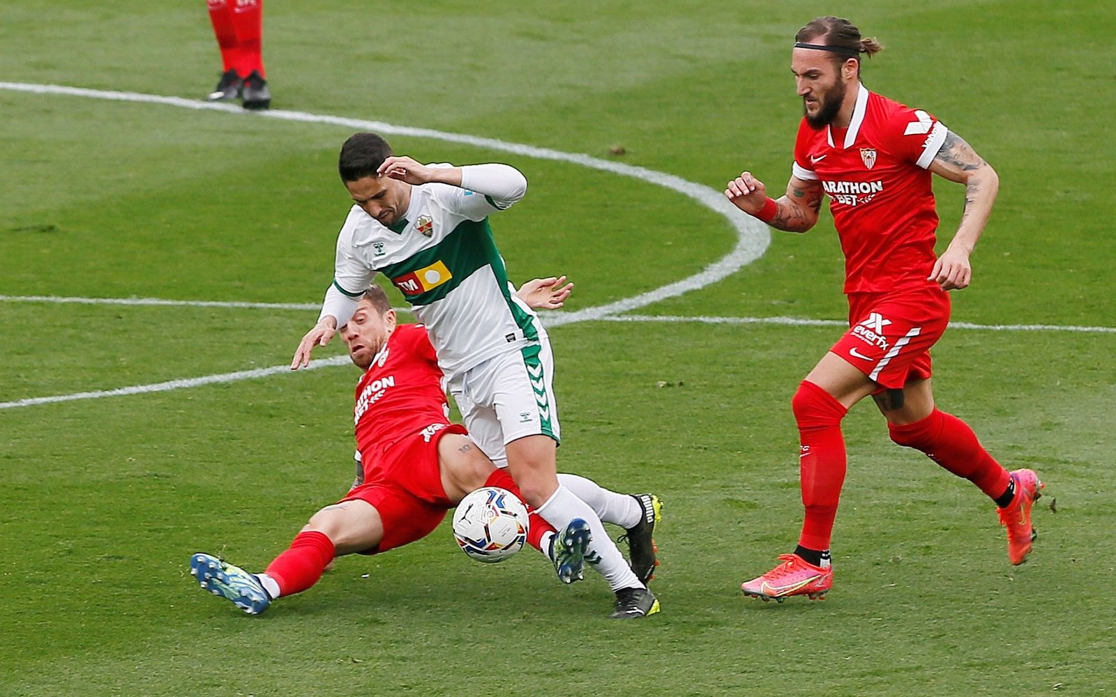 El Papu y Gudelj tratan de frenar a un rival.