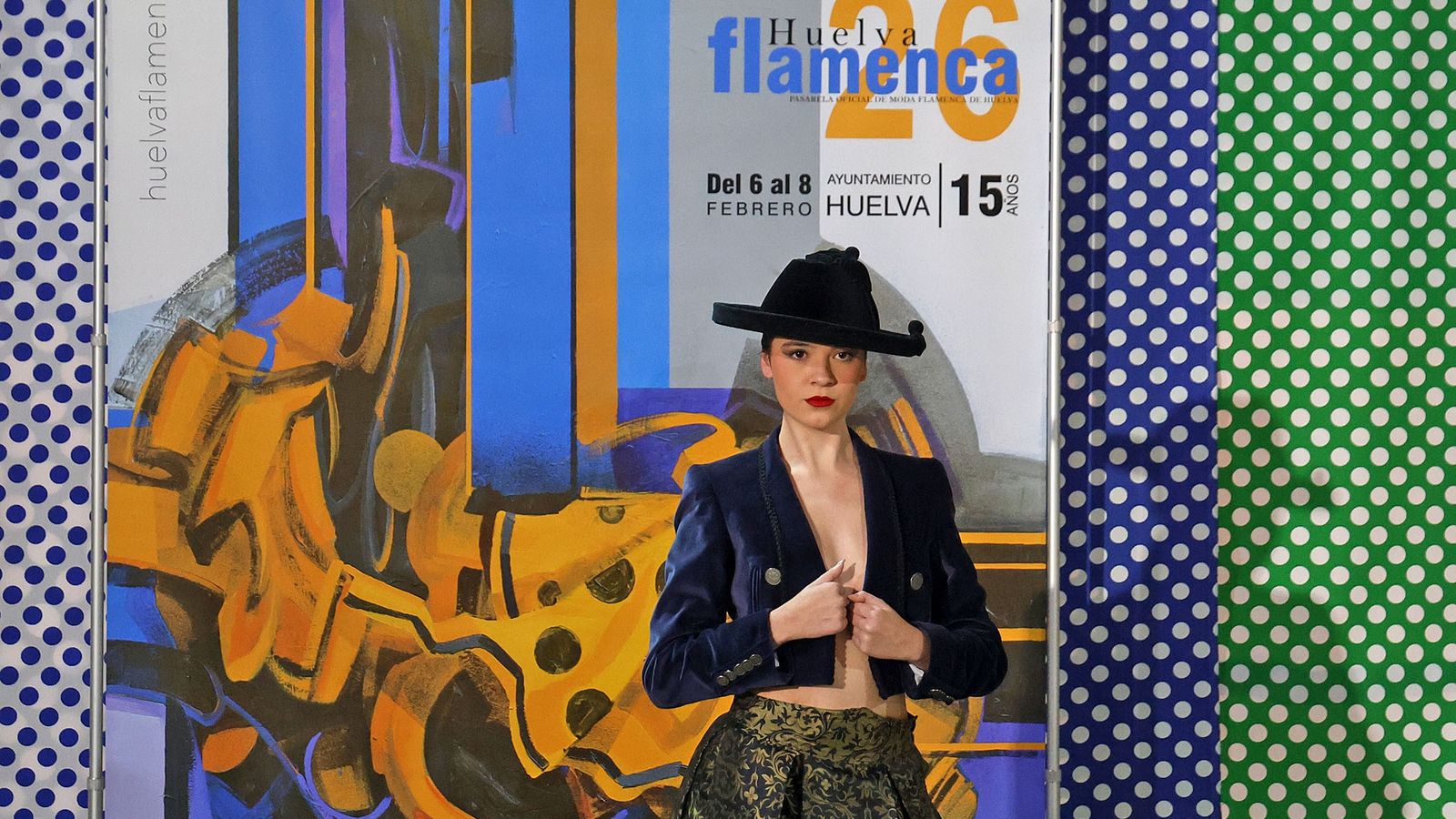 Una modela junto al cartel de la pasarela Huelva Flamenca 2026, el día de la presentación del mismo.