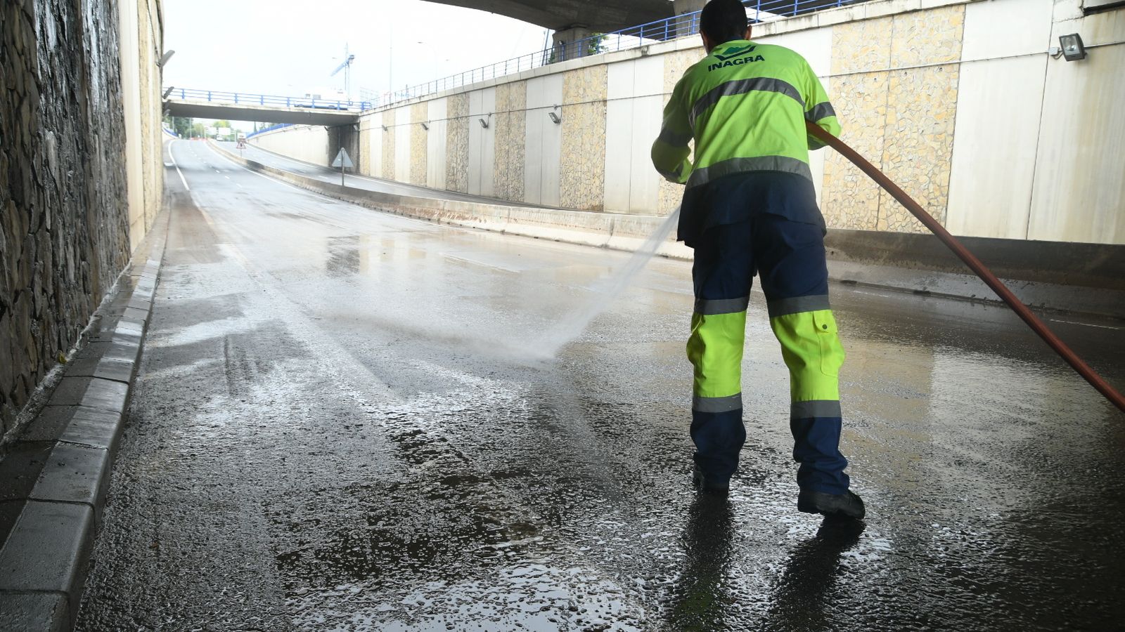 Un operario de Inagra limpia un paso subterráneo en la capital después de quedar inundado