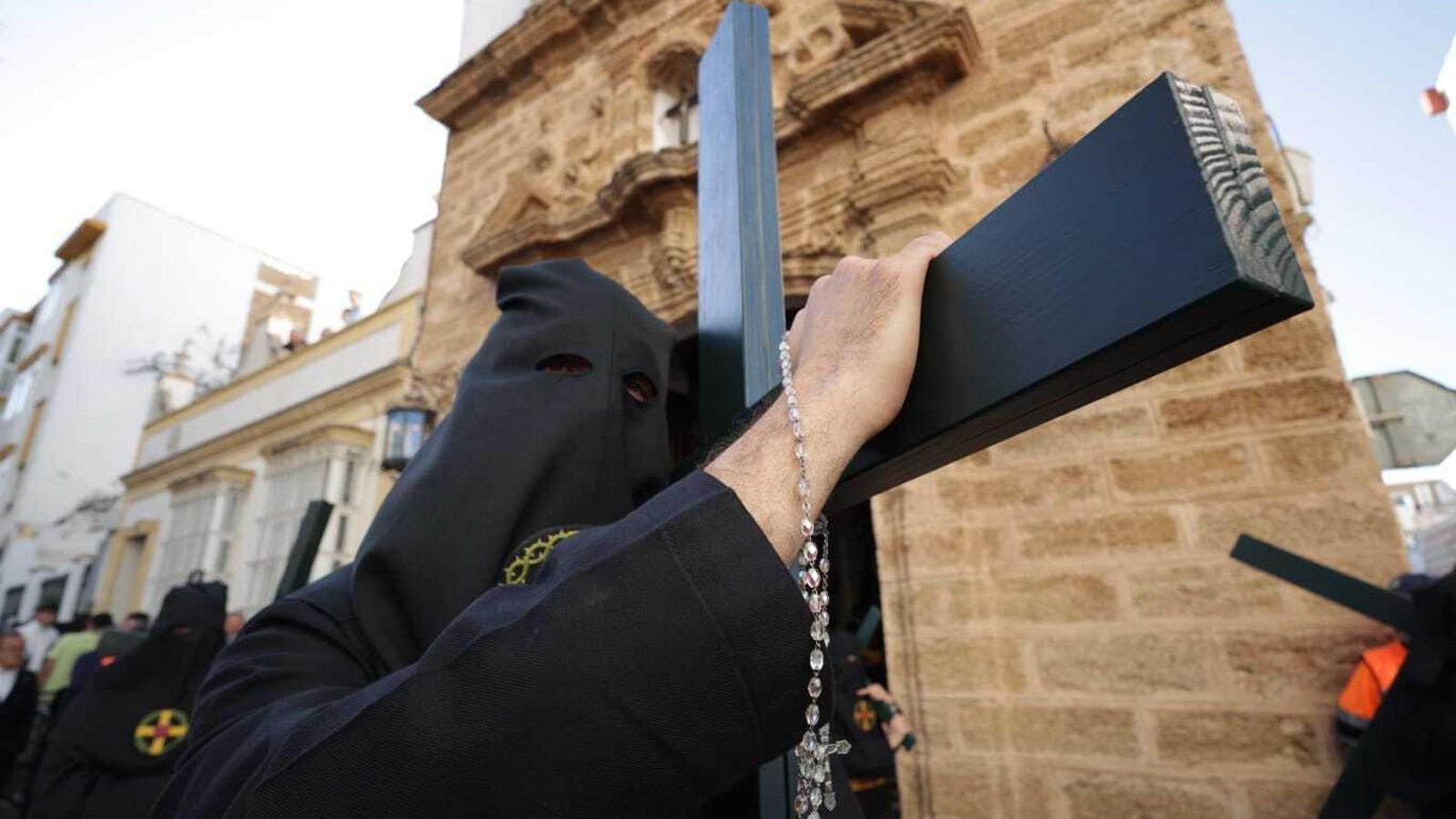 Un penitente de la hermandad de la Vera Cruz con la cruz al hombro.